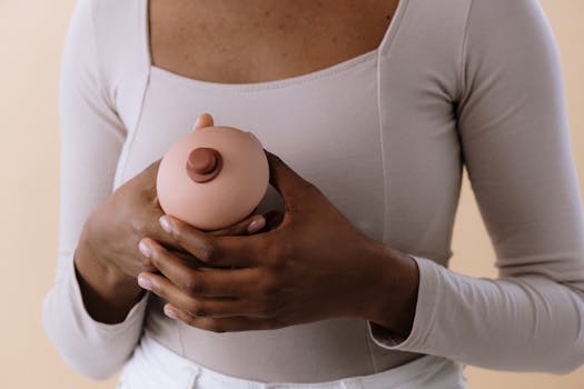 A woman holding a breast model, symbolizing breast cancer awareness and health education.